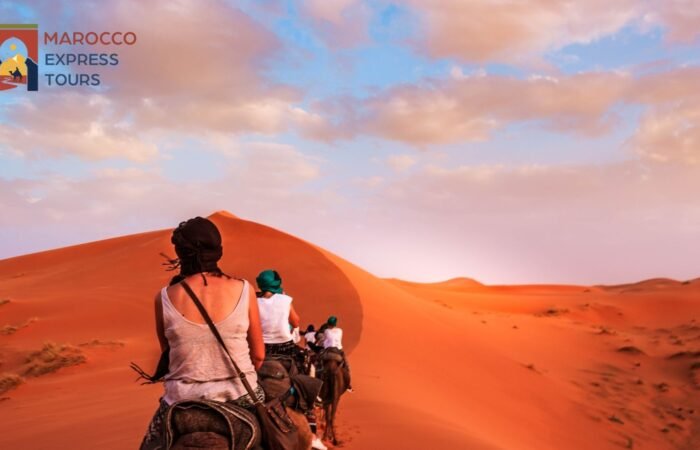 Due viaggiatori davanti alla grande duna al tramonto