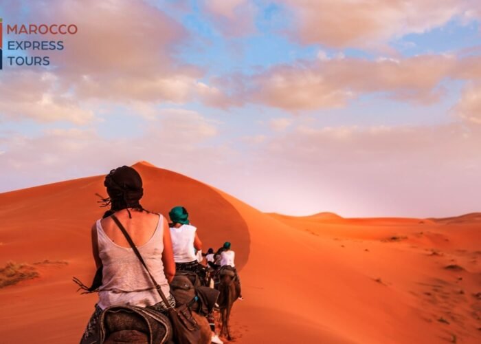 Due viaggiatori davanti alla grande duna al tramonto